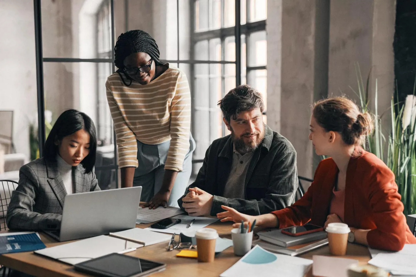 Diverse team collaborates at modern office workspace.