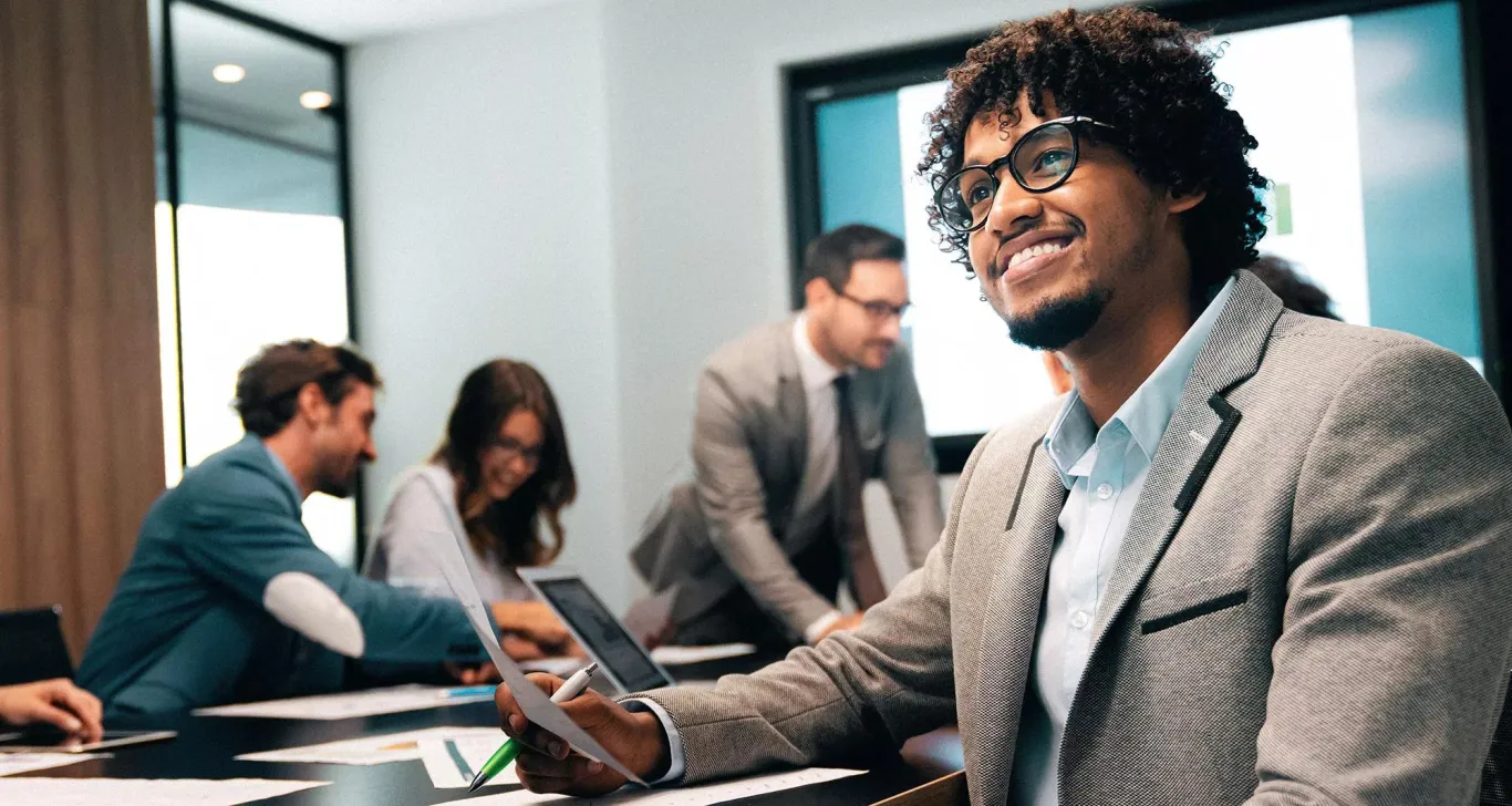 Multiple professionals attending a business meeting in a conference room.