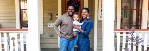 Portrait of black family and child in front of home for the holidays. Portrait of black family and child in front of home for the holidays.