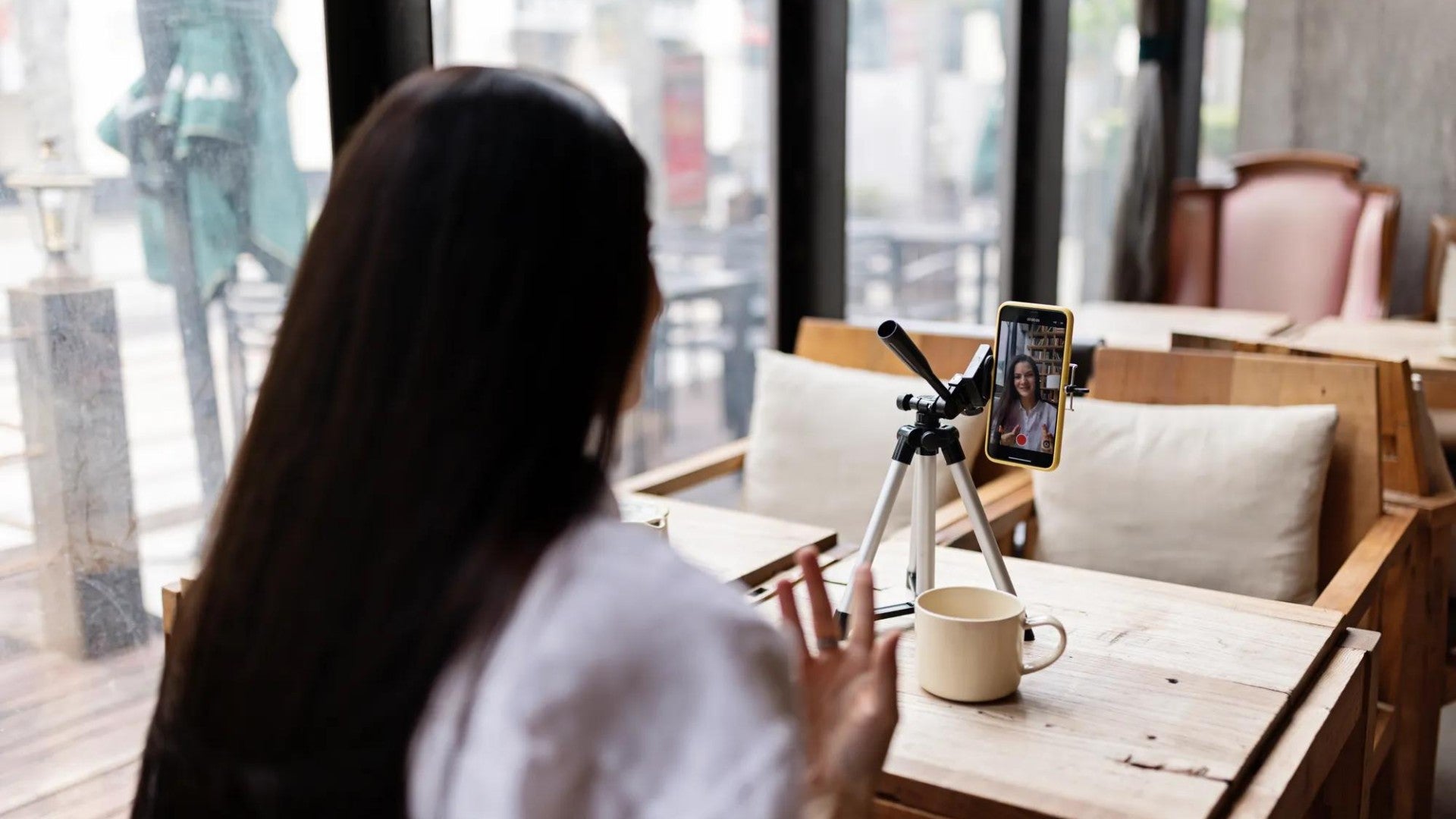 Woman recording a video on her cell phone as a side hustle