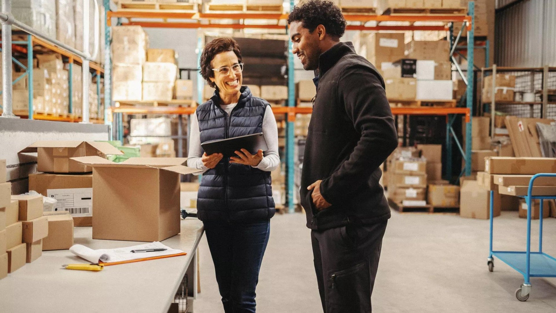 A man and a woman talking in a large shop environment.
