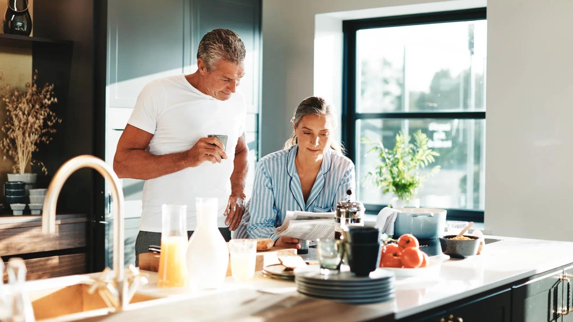 A married couple in their house looking at papers.