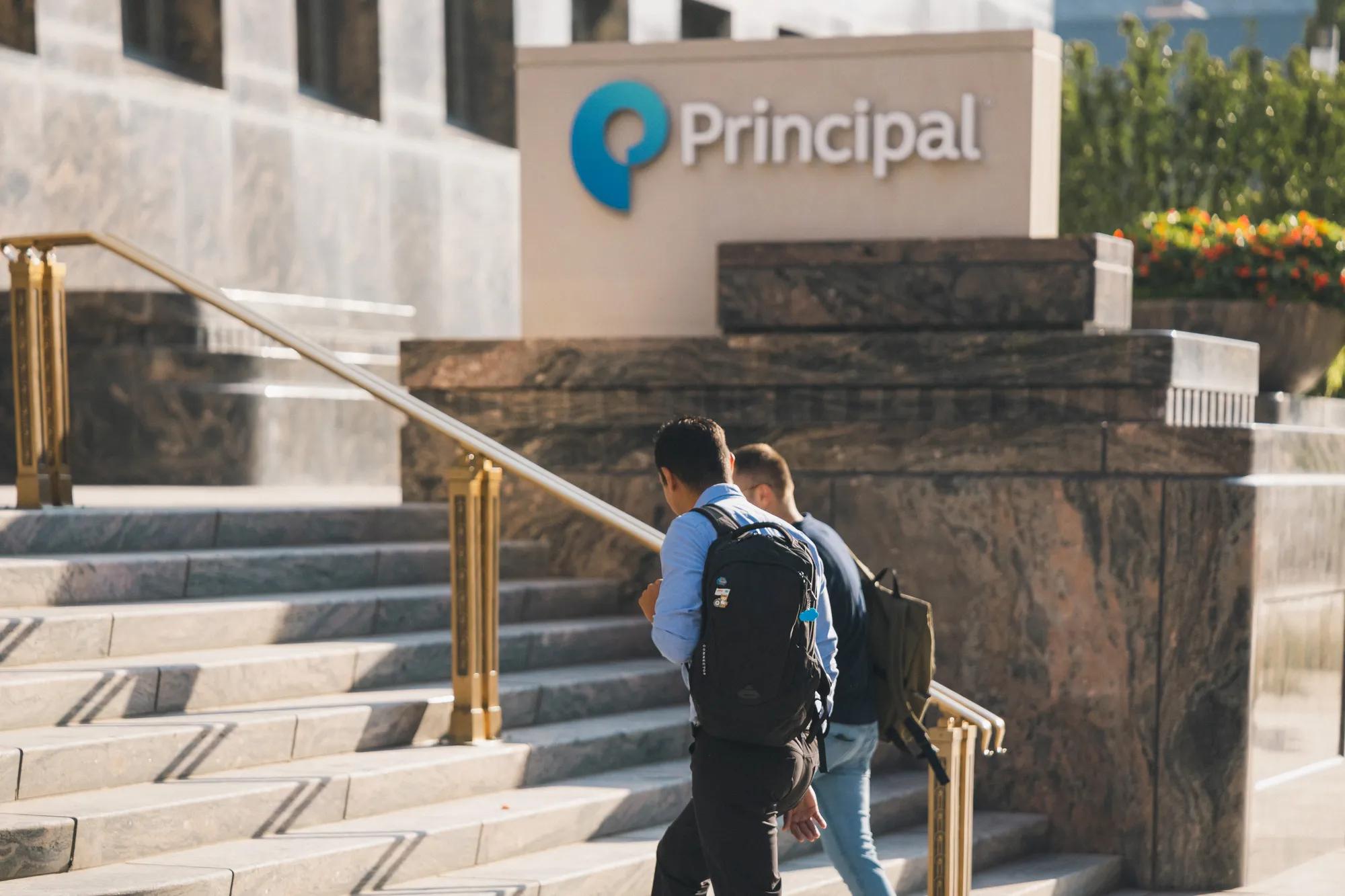 Two employees walking into a Principal headquarters building.