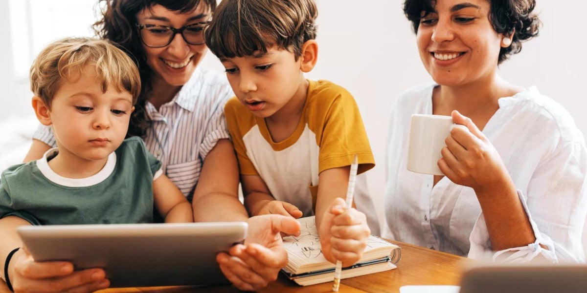 A family sitting together looking at a tablet.