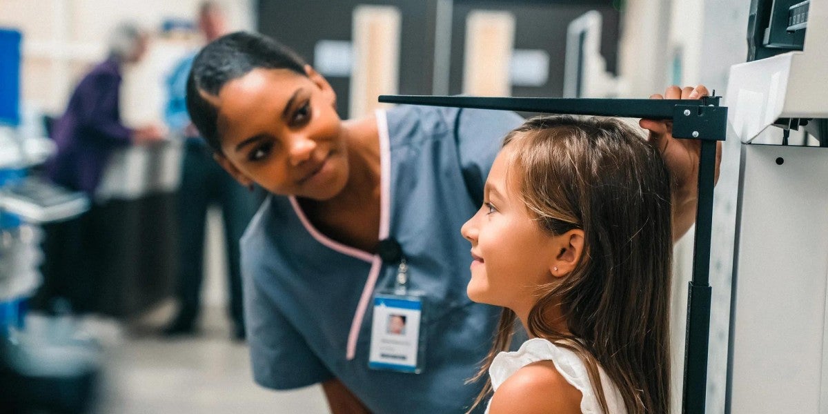 Nurse measuring height of girl