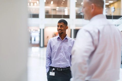 Two Principal employees talking at corporate headquarters