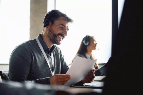 Man looking at a document with a headset on