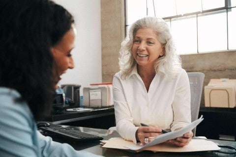 Senior professional woman meeting in office with young woman.