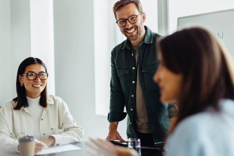 A small group of employees smiling while working together