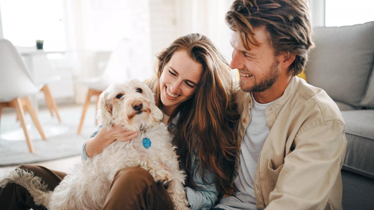 Man and woman sitting with a dog.