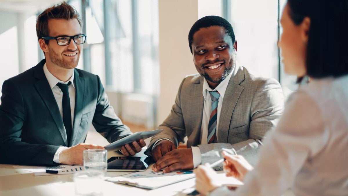 Three people talking in a meeting.