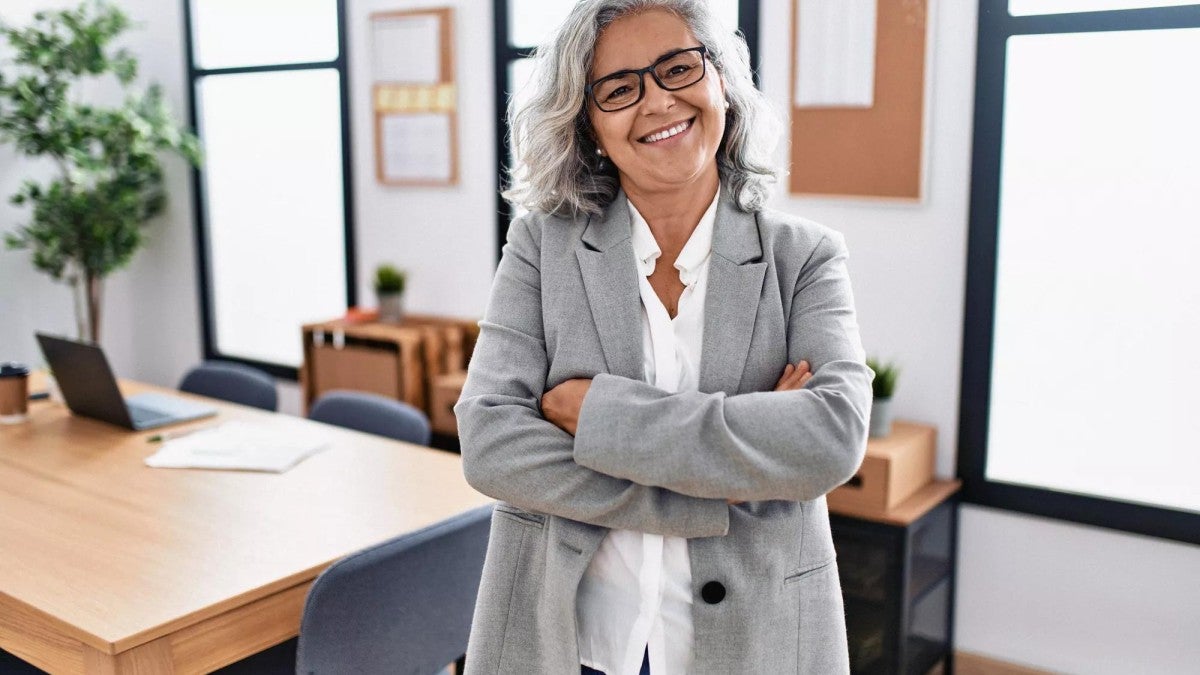 A happy woman smiling in an office setting.