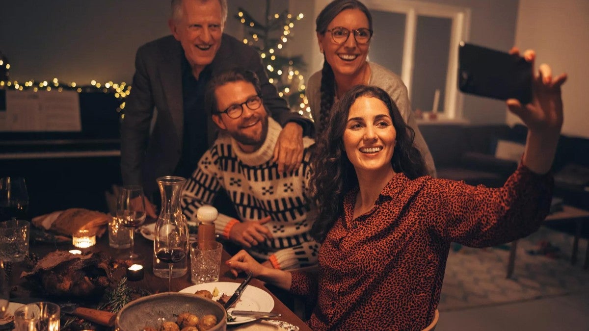 Family taking a selfie at the table in their home.