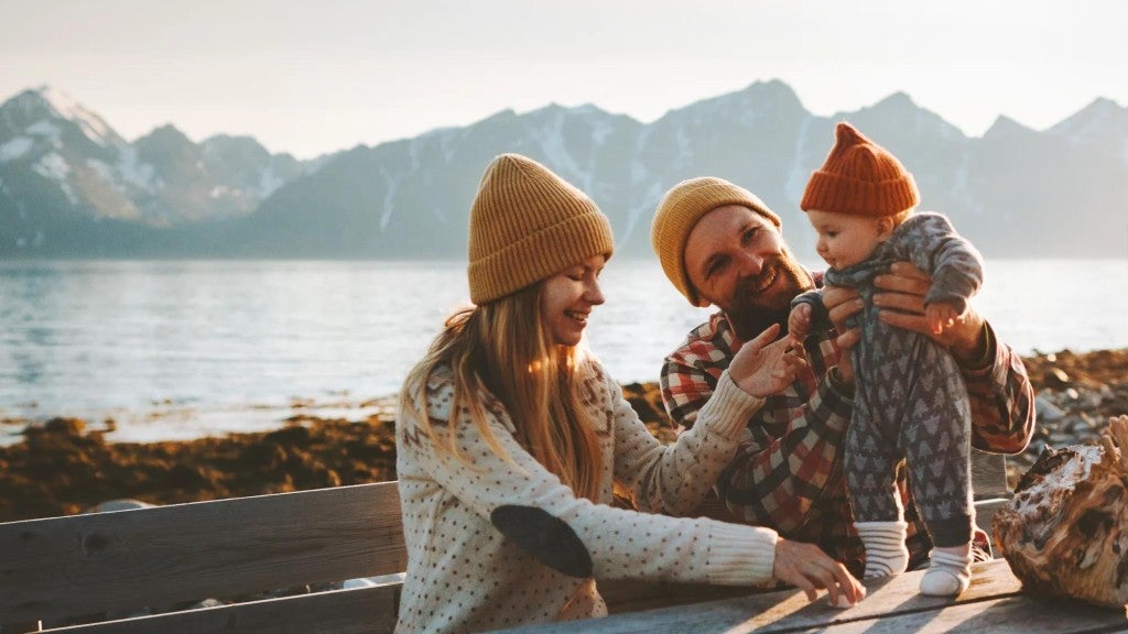 Mom and dad with young child sitting outside.