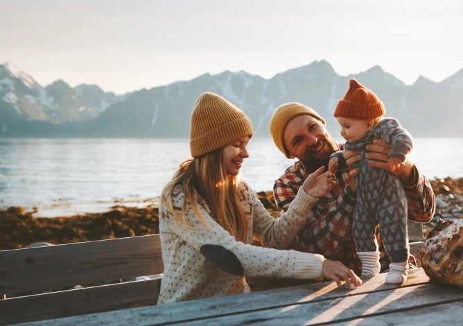 Mom and dad with young child sitting outside.