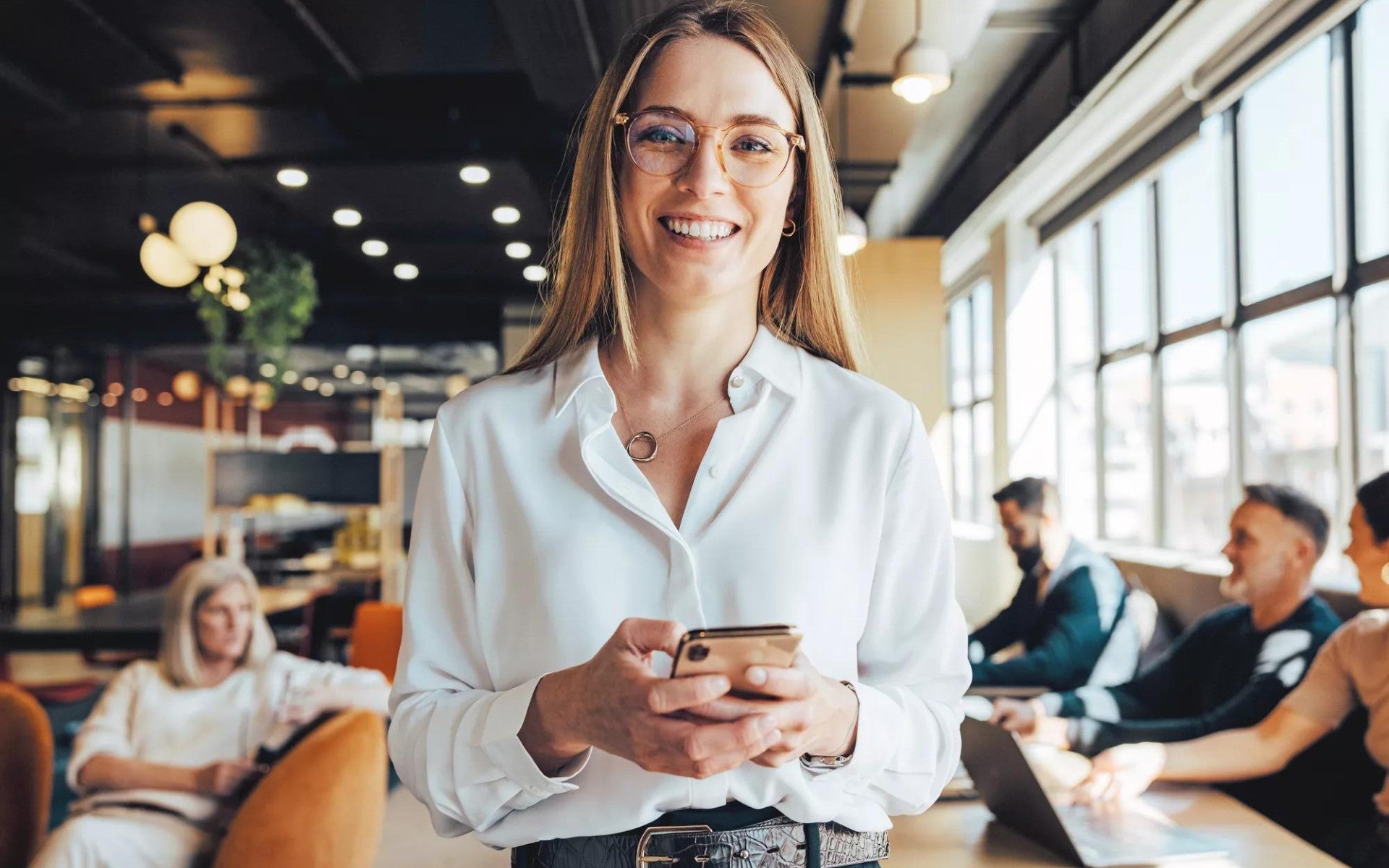 Woman smiling in a relaxed office setting.