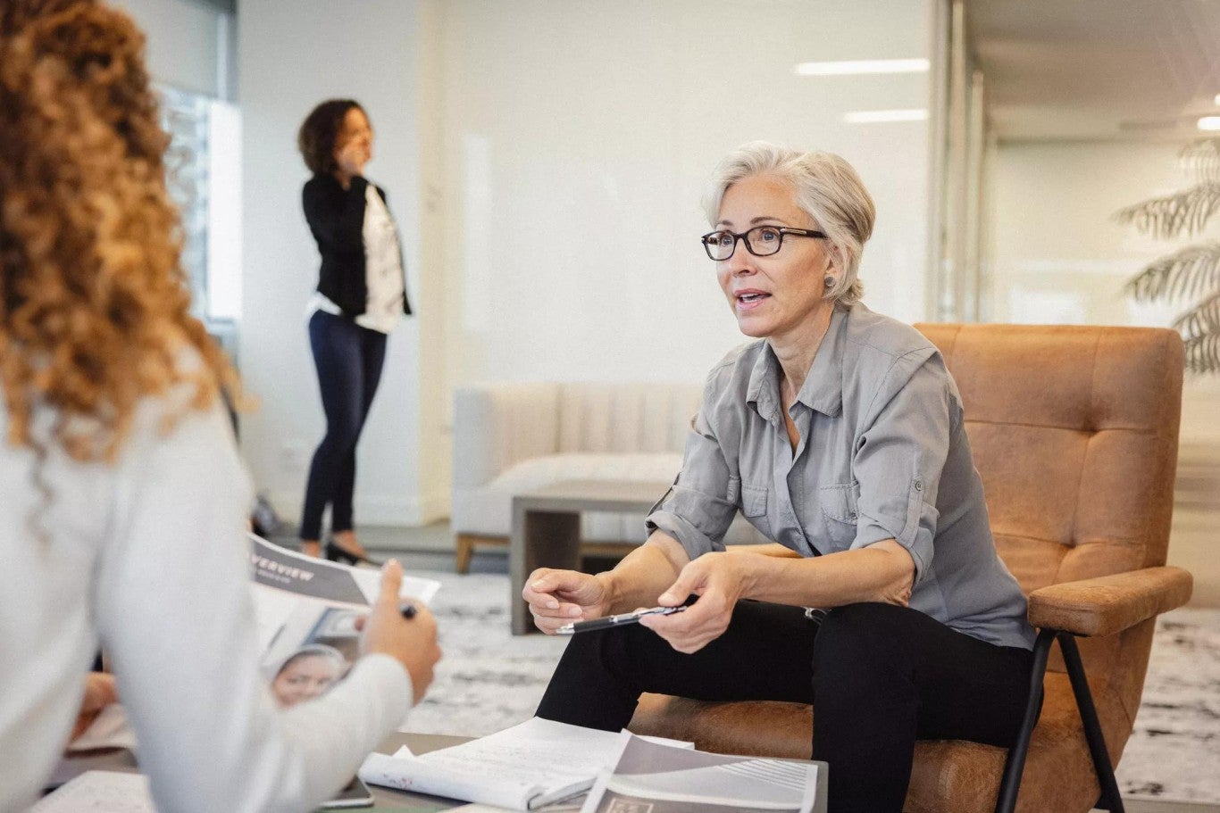 A female not-for-profit board trustee holding a pen and discussing investment services options for their nonprofit organization’