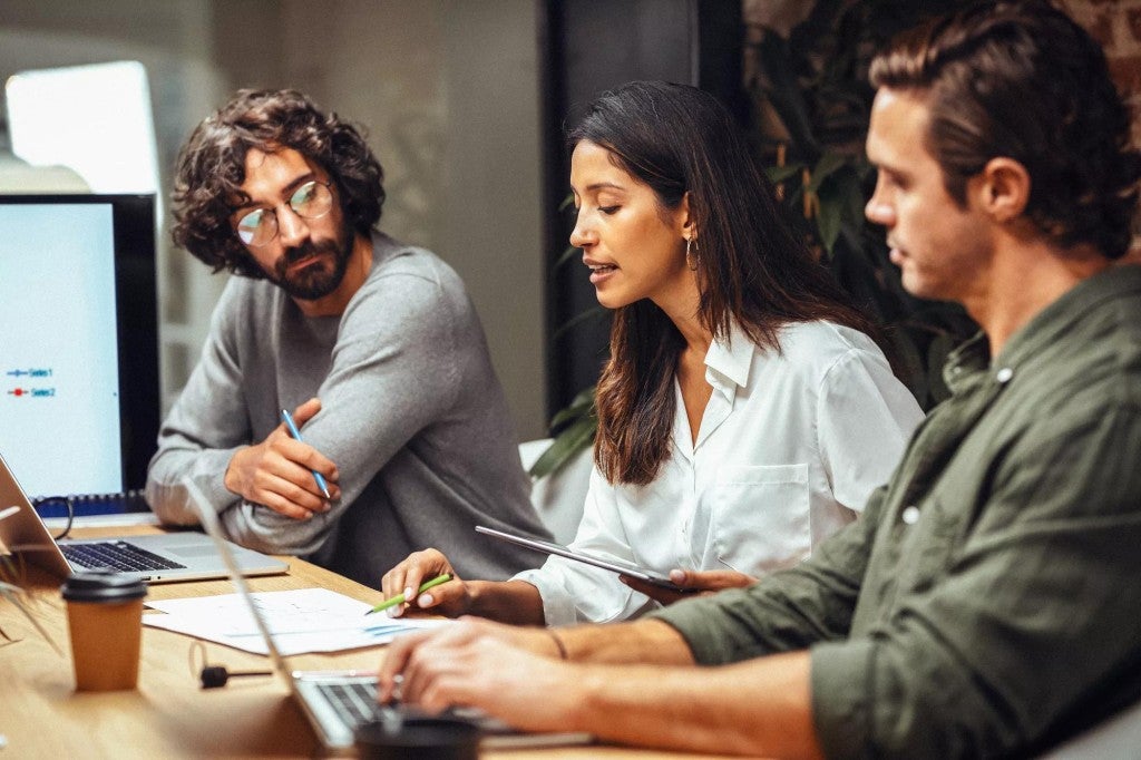 Woman and two men talking in a meeting