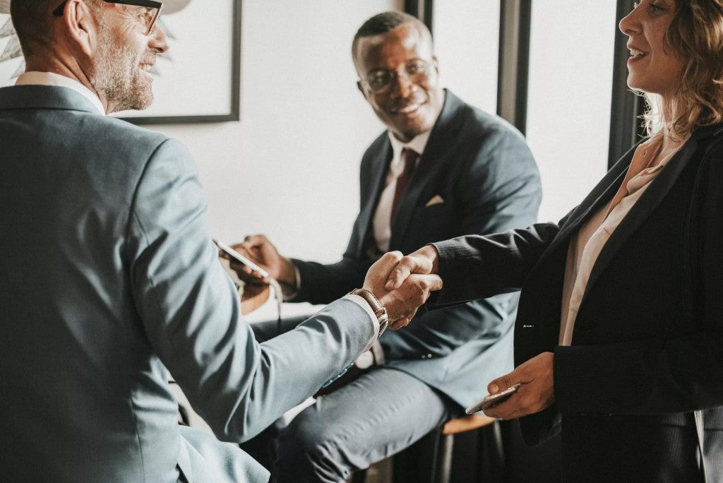 Three business partners shaking hands