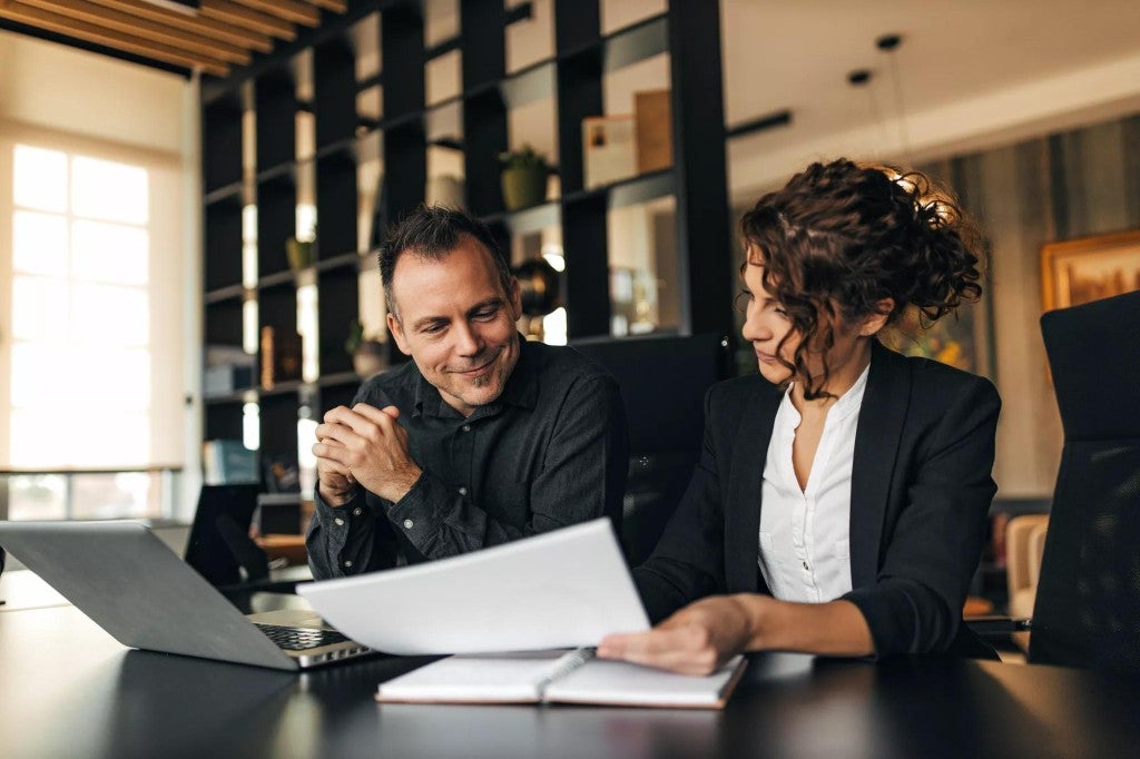 A man and a woman meeting in an office setting.