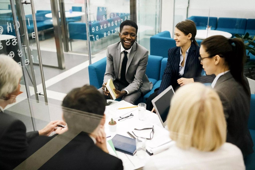 A group of young professionals meeting in an office setting.