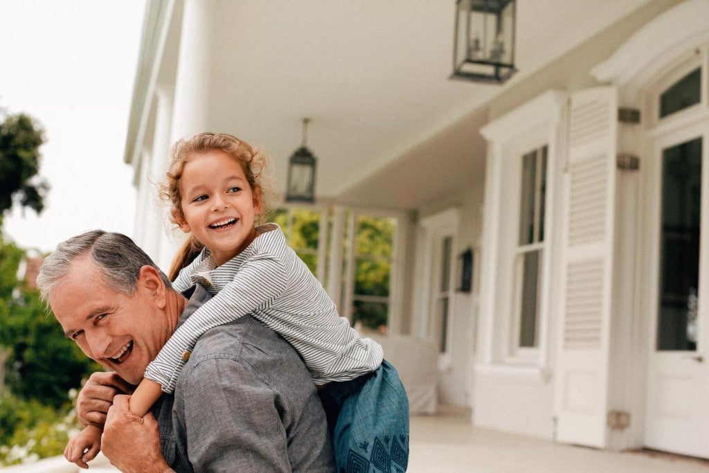 Man with granddaughter playing outside.