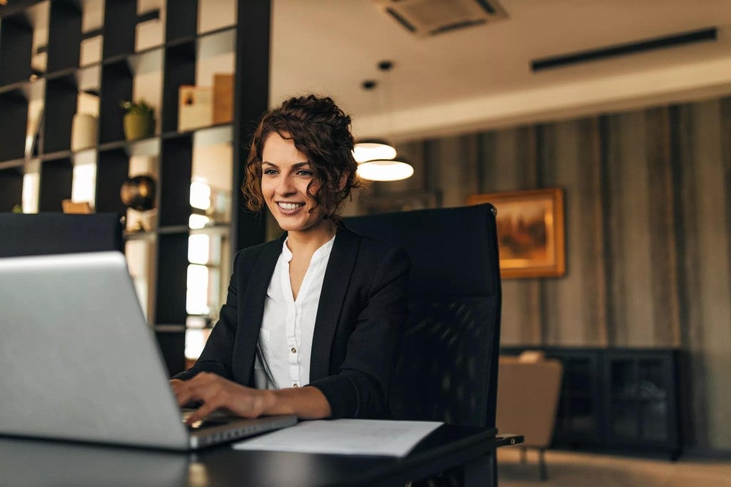 Woman at desk working on a laptop.