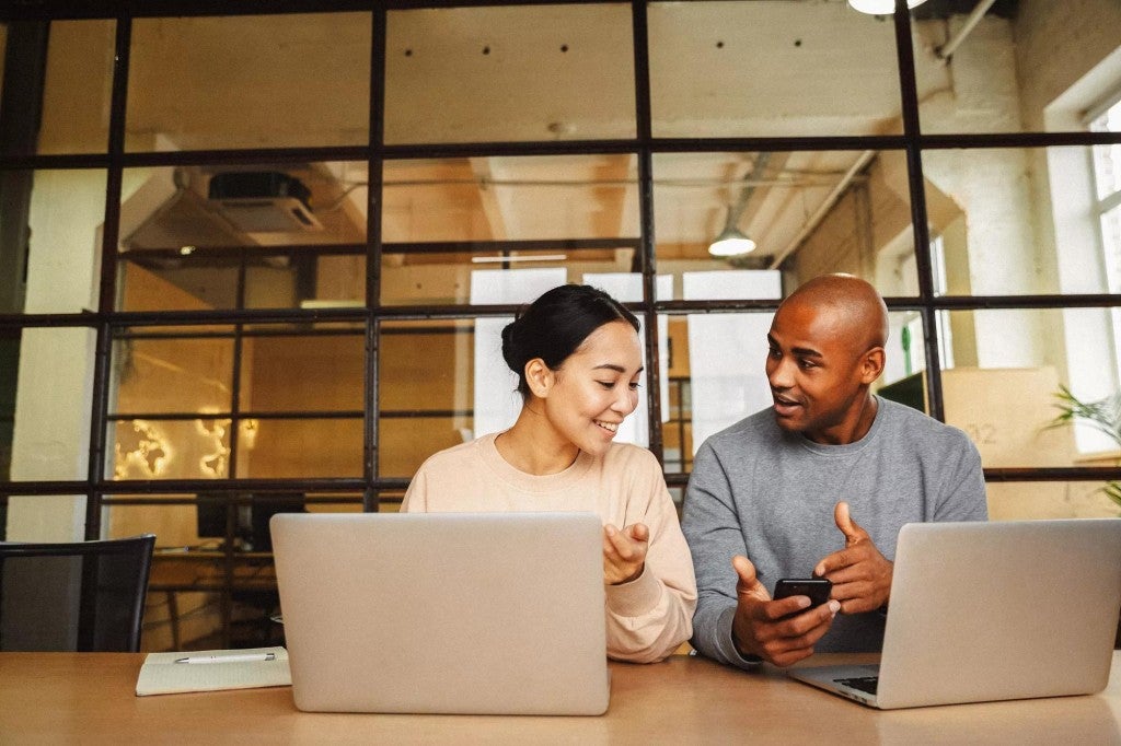 A man and a woman conversing in an office setting.