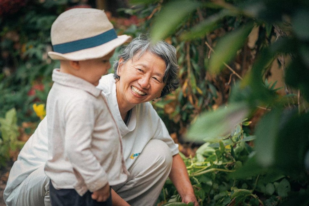 A happy grandmother with her grandchild outdoors.