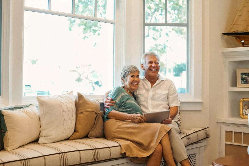 A couple sitting on their sofa in their home.